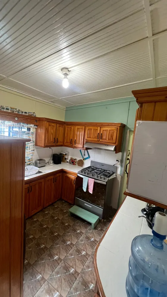 The cottage kitchen with timber cabinets, a cooker and preparation space.