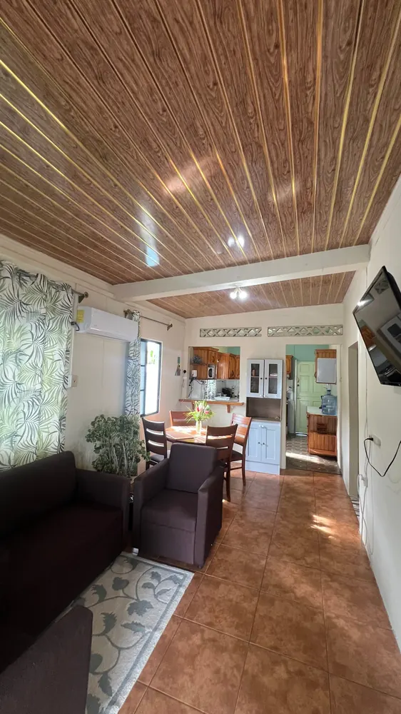 Living and dining space with a timber ceiling and the kitchen beyond.